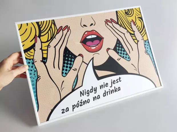 Plakat w białej ramie z komiksową grafiką kobiety i napisem Nigdy nie jest za późno na drinka