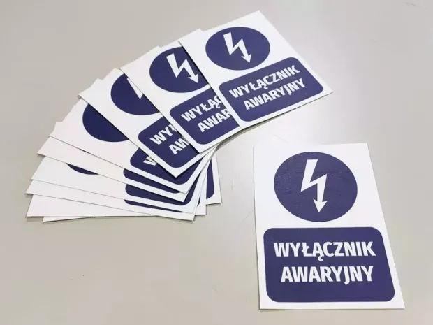 Niebieskie naklejki BHP Wyłącznik awaryjny z piktogramem błyskawicy pokazane jako zestaw kilku sztuk