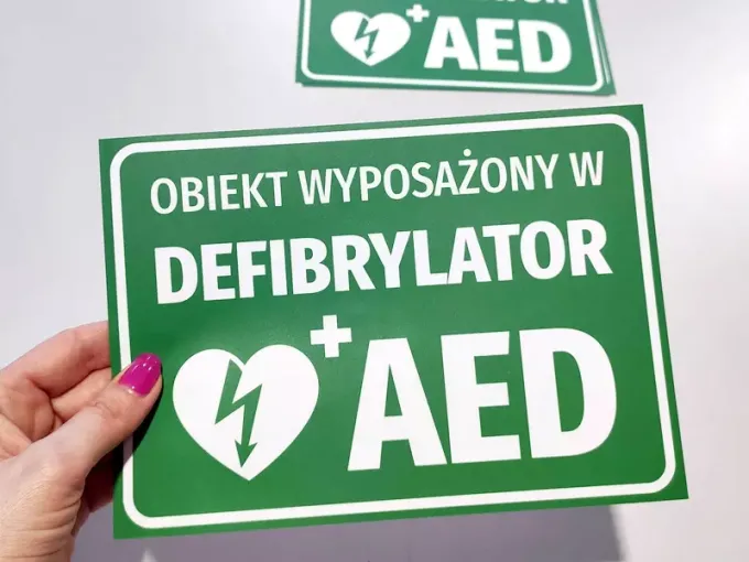 Naklejka Obiekt wyposażony w defibrylator AED - Wzór graficzny. Zielone tło z białym tekstem i symbolem serca