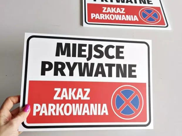 Tabliczka Miejsce prywatne Zakaz parkowania trzymana w dłoni, pokazująca rzeczywisty produkt i jego wielkość