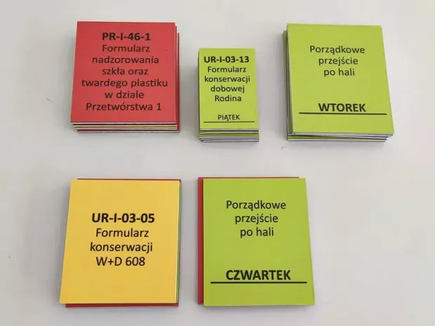 Dwustronne magnesy z rdzeniem PCV w postaci stosów prostokątnych tabliczek z przykładowym nadrukiem informacyjnym