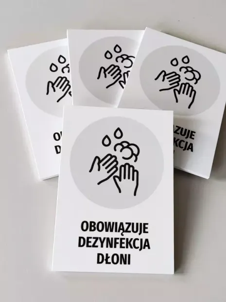 Tabliczka Obowiązuje dezynfekcja dłoni T481 - Wzór graficzny. Grafika przedstawia dłonie z kroplami płynu dezynfekującego