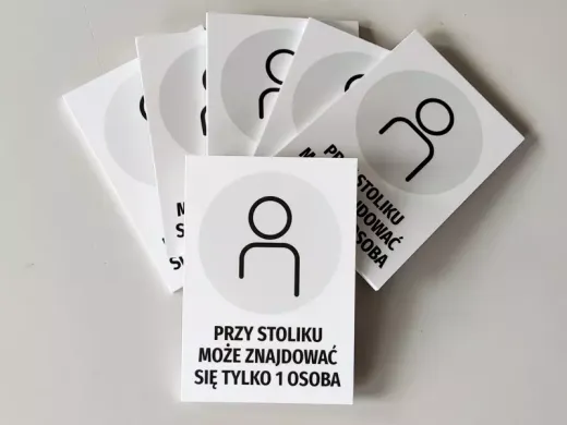 Zestaw kilku tabliczek informacyjnych Przy stoliku może znajdować się tylko 1 osoba ułożonych w wachlarz
