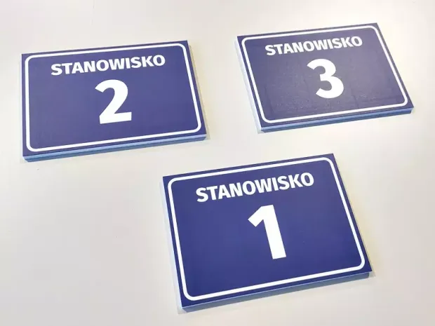 Tabliczka Stanowisko wraz z numerem, literą - Wzór graficzny. Proste prostokątne tabliczki z białym napisem na niebieskim