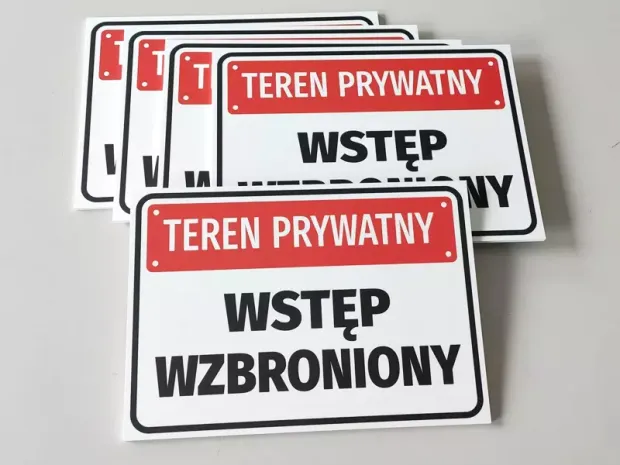 Zestaw kilku gotowych tabliczek ostrzegawczych z napisem Teren prywatny wstęp wzbroniony w czerwono-białej kolorystyce