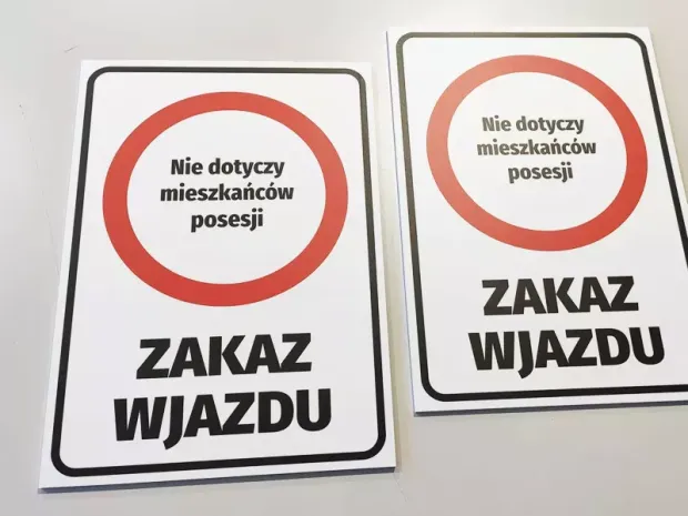 Dwie tabliczki Zakaz wjazdu - Nie dotyczy mieszkańców posesji z czerwonym znakiem zakazu na płaskiej powierzchni