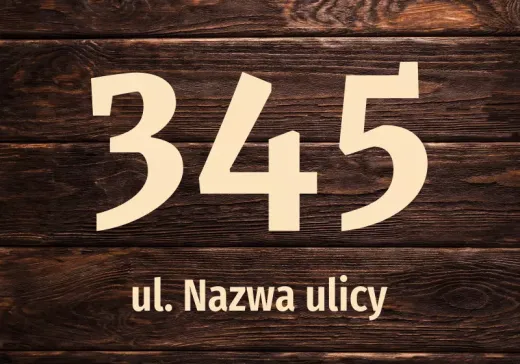 Naklejka adresowa naklejona na drewnianą powierzchnię z przykładowym numerem oraz ulicą