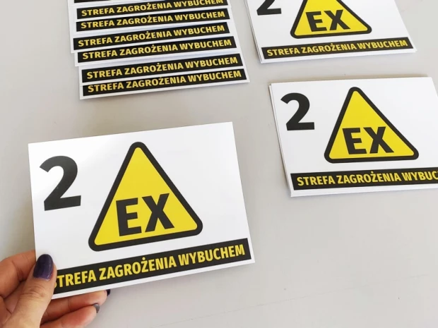 Naklejka Strefa zagrożenia wybuchem N267 - Wzór graficzny. Żółty trójkąt z czarnym napisem EX i czarnym tłem