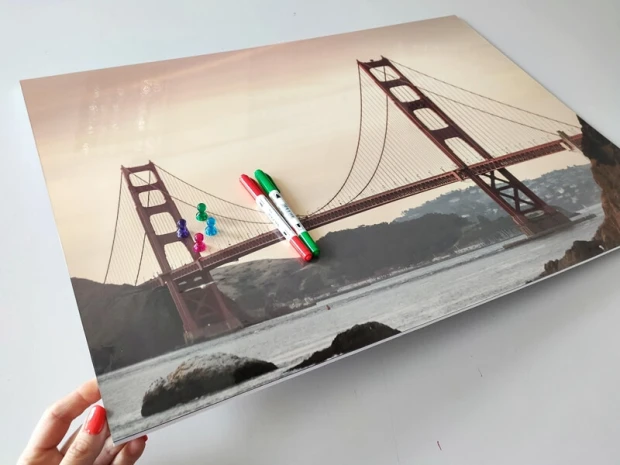 Tablica magnetyczna z nadrukiem mostu Golden Gate w ujęciu pokazującym grubość płyty, z markerami i magnesami