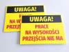 Tabliczka Uwaga Prace na wysokości - przejścia nie ma - Wzór graficzny. Żółte tło z czarnym napisem i dużymi, czerwonymi