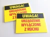 Tabliczka Uwaga Urządzenie wyłączone z ruchu - Wzór graficzny. Żółte tło z dużym czarnym napisem UWAGA! oraz czerwonym