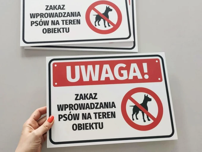 Tabliczka Uwaga Zakaz wprowadzania psów na teren obiektu - Wzór graficzny. Prostokątna tabliczka z czerwonymi okręgami
