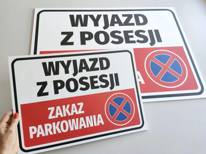 Tabliczka Wyjazd z posesji, zakaz parkowania - Wzór graficzny. Prostokątna tabliczka z dużymi literami i piktogramem zakazu