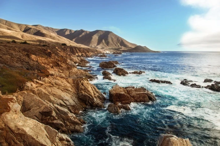 Fototapeta na ścianę skalisty brzeg morza FP 6446 - Wzór graficzny. Widoczne skały, fale i góry w tle