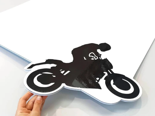 Prostokątna tablica suchościeralna z nadrukiem motocyklisty wyciętym po obrysie, pokazana z bliska