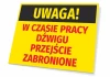 Tabliczka Uwaga W czasie pracy dźwigu przejście zabronione - Wzór graficzny. Prostokątna tabliczka z żółtym tłem, czarnym