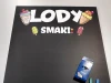 Tablica kredowa lody 057 - Wzór graficzny. Na czarnym tle znajdują się kolorowe lody oraz napis LODY SMAKI