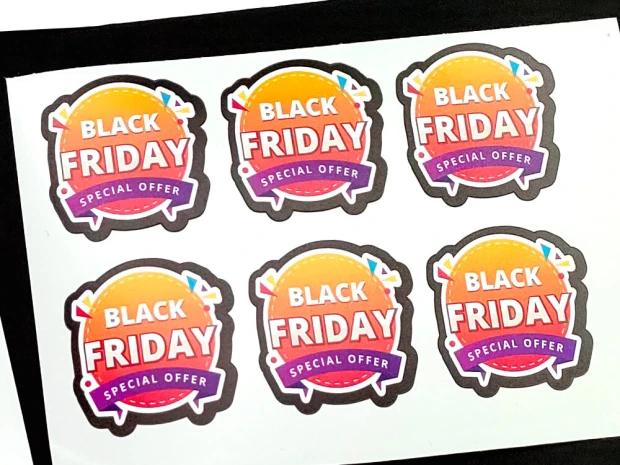 Etykiety samoprzylepne na arkuszu z przykładowym nadrukiem reklamowym Black Friday, wycięte po obrysie