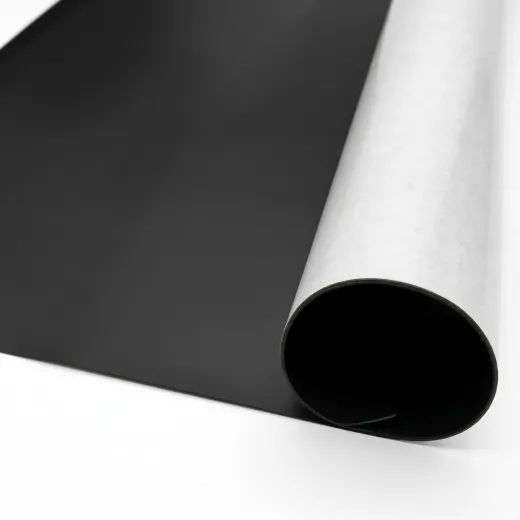 Folia magnetyczna w rolce pokazująca czarną stronę magnetyczną oraz białą warstwę samoprzylepną z klejem