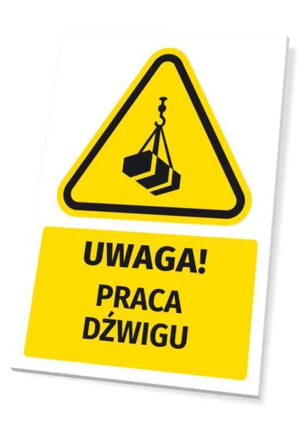 Żółta tabliczka ostrzegawcza BHP z czarnym piktogramem i napisem UWAGA! PRACA DŹWIGU, pokazana na białym tle