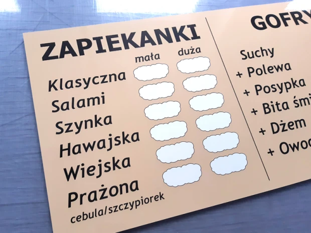 Tablica suchościeralna z nadrukiem menu gastronomicznego w zbliżeniu pokazującym błyszczącą powierzchnię