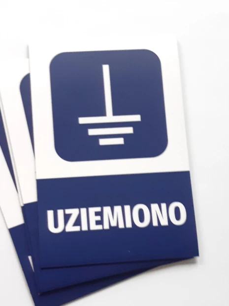 Prostokątne magnesy z przykładowym nadrukiem UZIEMIONO, ułożone w wachlarz na białym tle