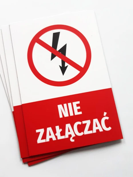 Prostokątne magnesy z przykładowym nadrukiem NIE ZAŁĄCZAĆ, ułożone w stos na białym tle