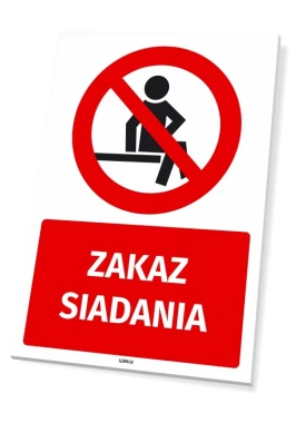 Tabliczka BHP Zakaz siadania - Wzór graficzny. Czerwony okrąg z przekreśloną postacią siedzącą, pod nim napis ZAKAZ SIADANIA