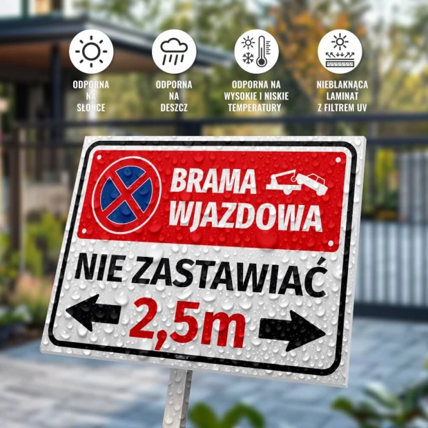 Tabliczka Brama wjazdowa nie zastawiać z polem na szerokość bramy, pokryta kroplami wody na tle ogrodzenia