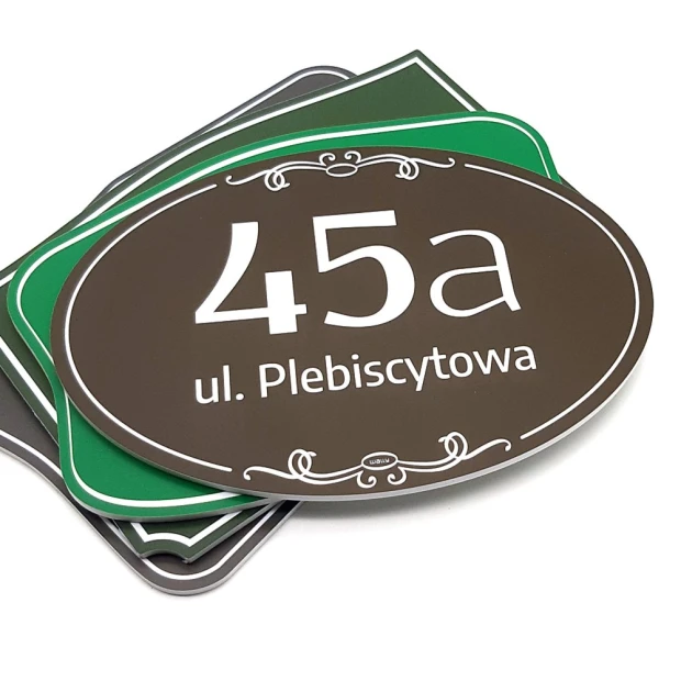 Porównanie wariantów kolorystycznych owalnej tabliczki adresowej z miejscem na numer domu i nazwę ulicy