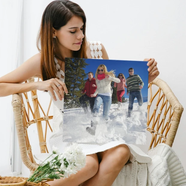 Plakat fotoplakat ze zdjęcia 40x50 cm - Aranżacja w jasnym pomieszczeniu. Osoba trzyma plakat z grupą ludzi w śniegu
