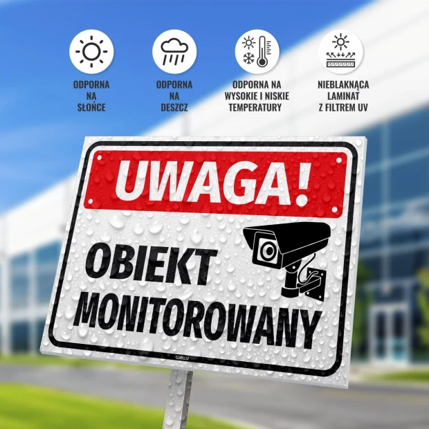 Tabliczka Uwaga obiekt monitorowany - Wzór graficzny. Prostokątna tabliczka z czarnym napisem na białym tle, z symbolem