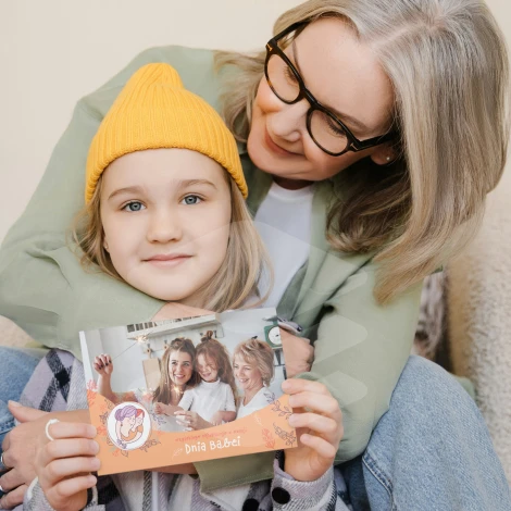 Plakat ze zdjęcia 30x40 cm na ważne okazje - Aranżacja w salonie. Ściany w jasnym kolorze, na kanapie siedzą dwie osoby