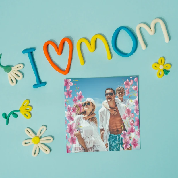 Plakat ze zdjęcia 50x50 cm na ważne okazje - Wzór graficzny. Kolorowe litery tworzą napis I love Mom, otoczone kwiatami