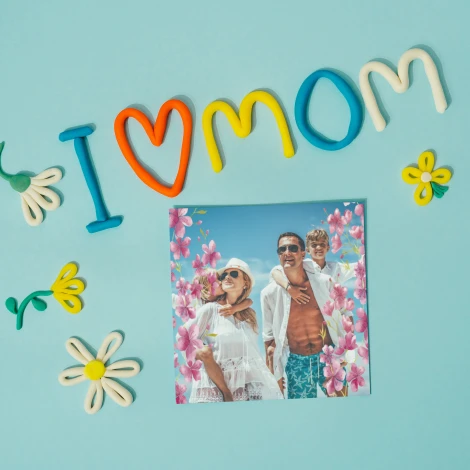 Plakat ze zdjęcia 50x50 cm na ważne okazje - Wzór graficzny. Kolorowe litery tworzą napis I love Mom, otoczone kwiatami