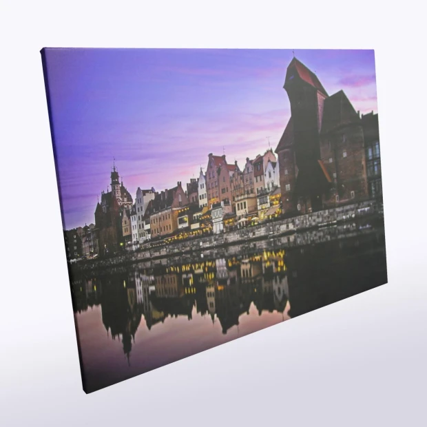 Obraz na płótnie ze zdjęcia 30x40 cm - Aranżacja w mieście. Widok na budynki nad rzeką w zmierzchowym świetle