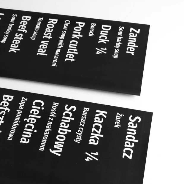 Folia magnetyczna suchościeralna z własnym nadrukiem - Wzór graficzny. Czarny tle z białym tekstem, różne nazwy potraw